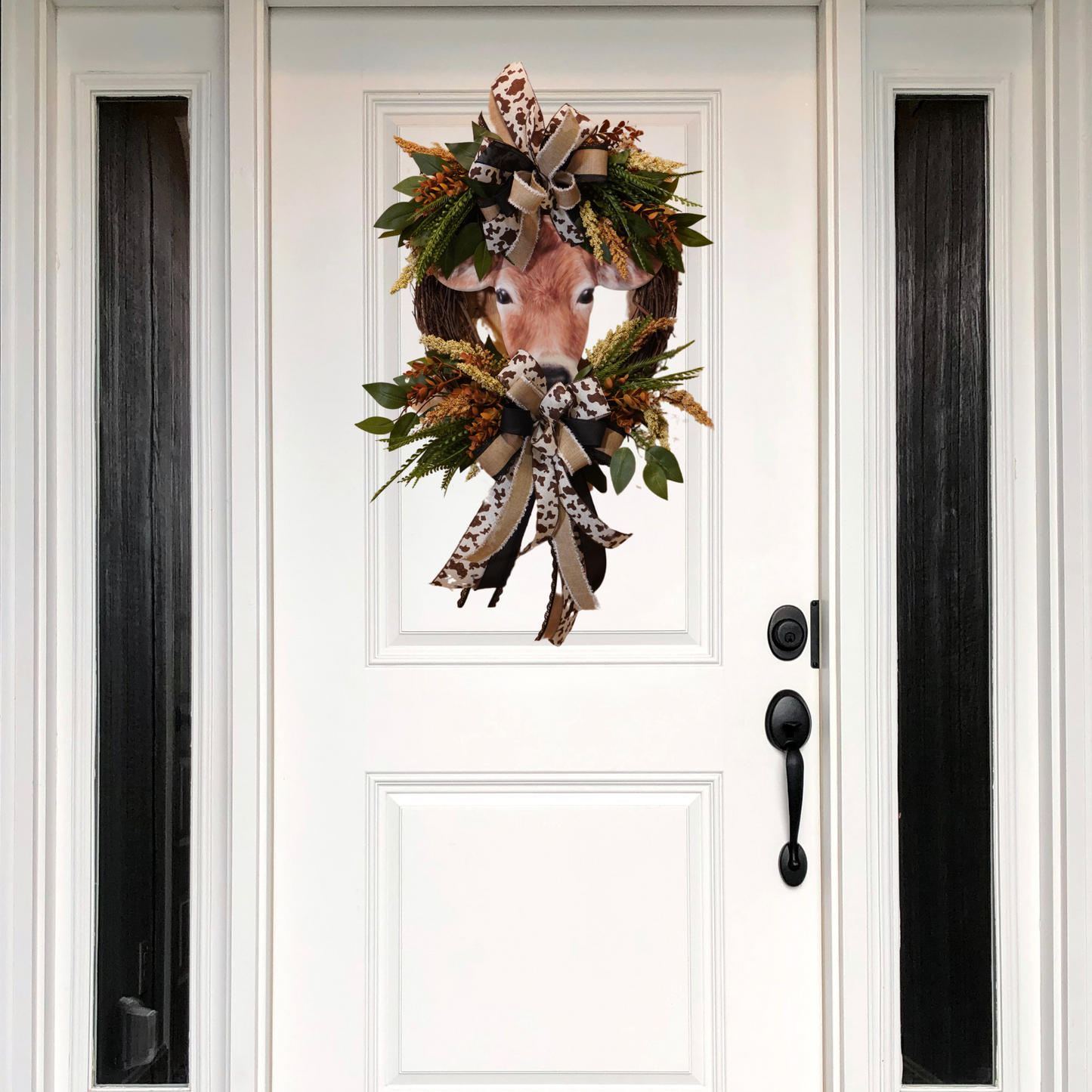 Brown Cow Fall wreath design with cow print ribbon, greenery, Fall florals, and embossed cow sign