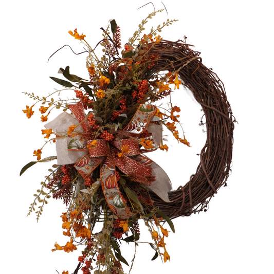 Fall grapevine wreath with Orange filler flowers and a large bow with Orange and Sage pumpkins